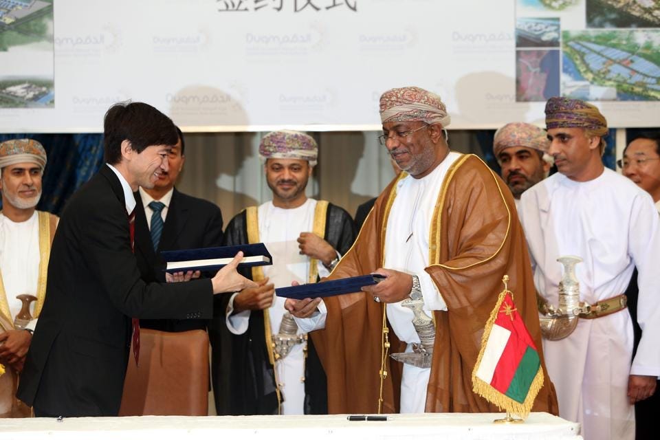 Omani Yahya bin Said bin Abdullah Al-Jabri, Minister of the Special Economic Zone Authority at... [+] A'Duqum (C-R) and Chinese Ali Shah, Chairperson of Oman Wanfang L.L.C shake hands after signing an economical agreement on May 23, 2016 in Muscat. (MOHAMMED MAHJOUB/AFP/Getty Images)