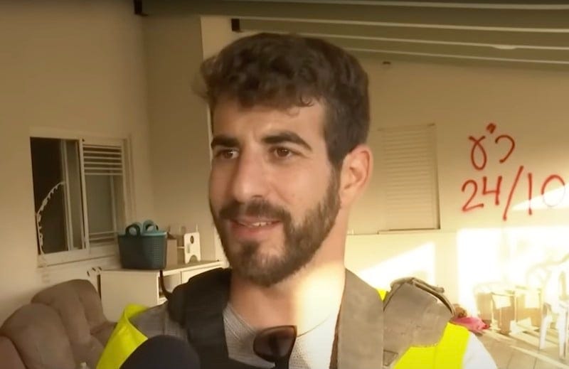 A man with a high-vis vest speaks to camera