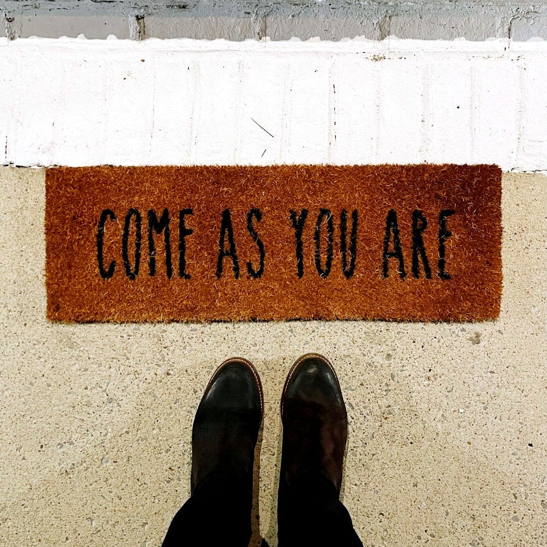 person standing on brown and black welcome printed floor mat
