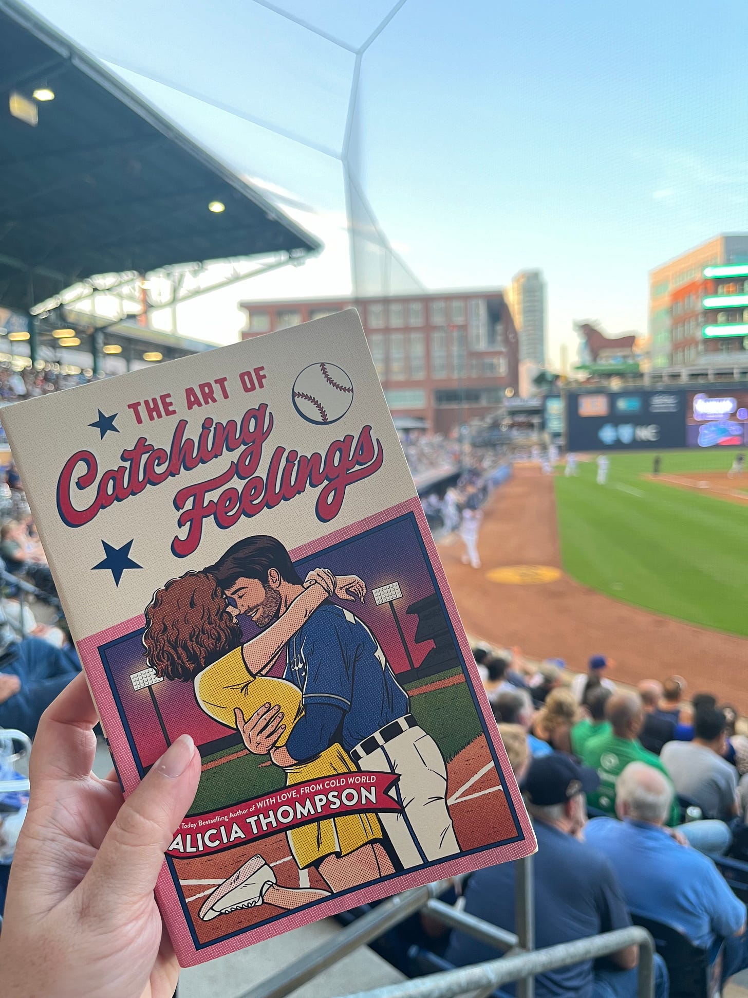 Picture of THE ART OF CATCHING FEELINGS held up in front of the field at Durham Bulls Athletic Park