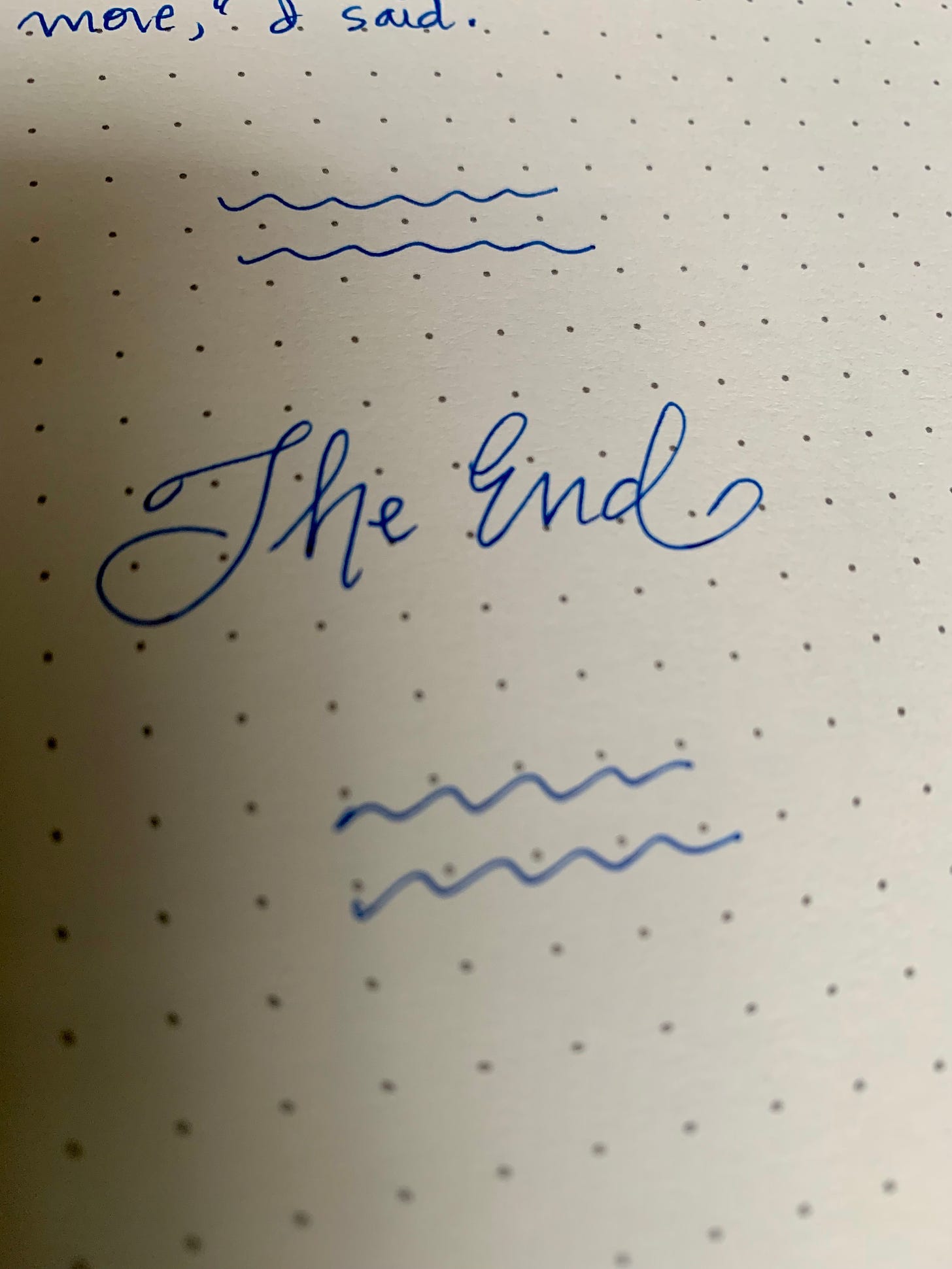A page in a notebook. In handwritten cursive are the words "The End"