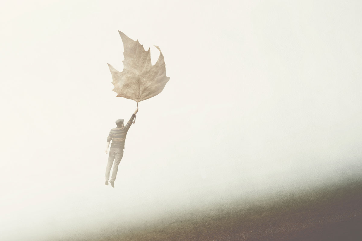 Man Floating While Hanging onto Maple Leaf