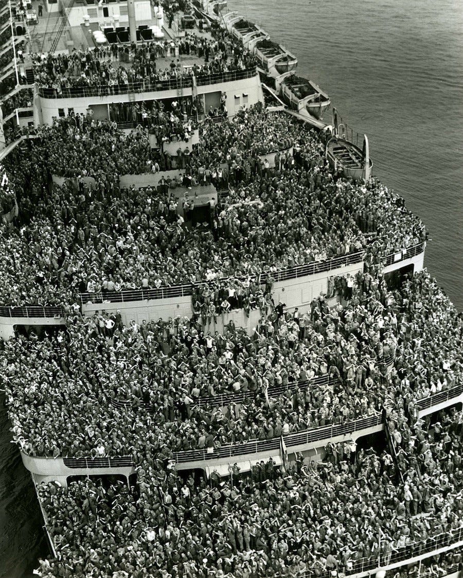 Black and white of an ocean liner packed with tousands of troops returning home after the Second World War