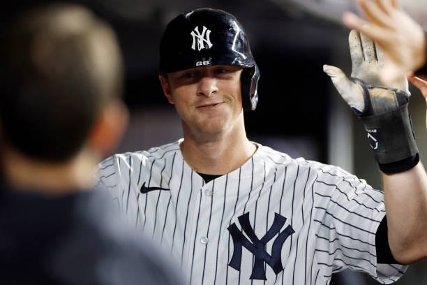 LeMahieu of the New York Yankees celebrates in the dugout after scoring on an RBI double hit by Aaron Judge during the seventh inning of the game...