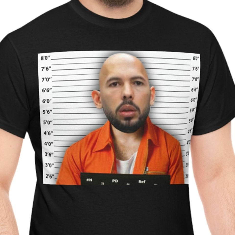 a man is wearing a black t-shirt with andrew tate's mugshot across the front. i am unsure if this is pro-andrew-tate or anti-andrew-tate