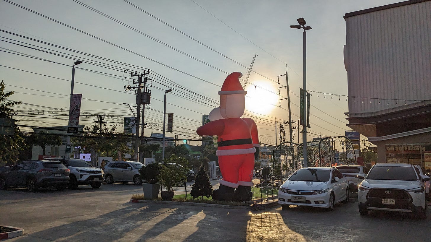 a sunny blown up santa on a busy street