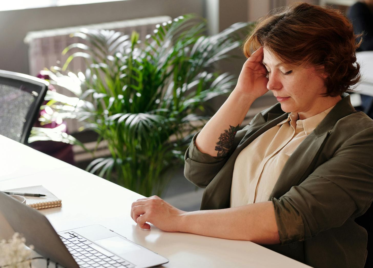 woman at desk with headache