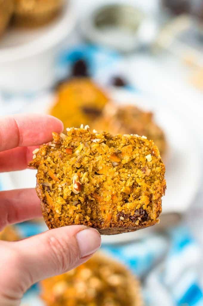 A hand holding a cut morning glory muffin. A hand holding a cut morning glory muffin.