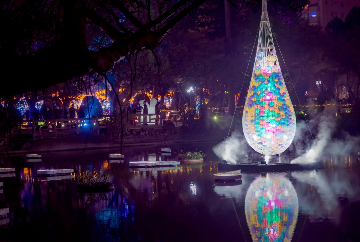 Steam rises around the base of a glowing pendant lantern in the Sun Yat Sen Memorial Hall pond at the Taiwan Lantern Festival