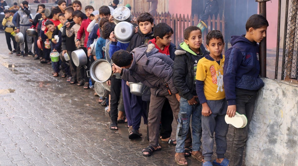 Palestinian boys are queuing outside with pots to get food. 