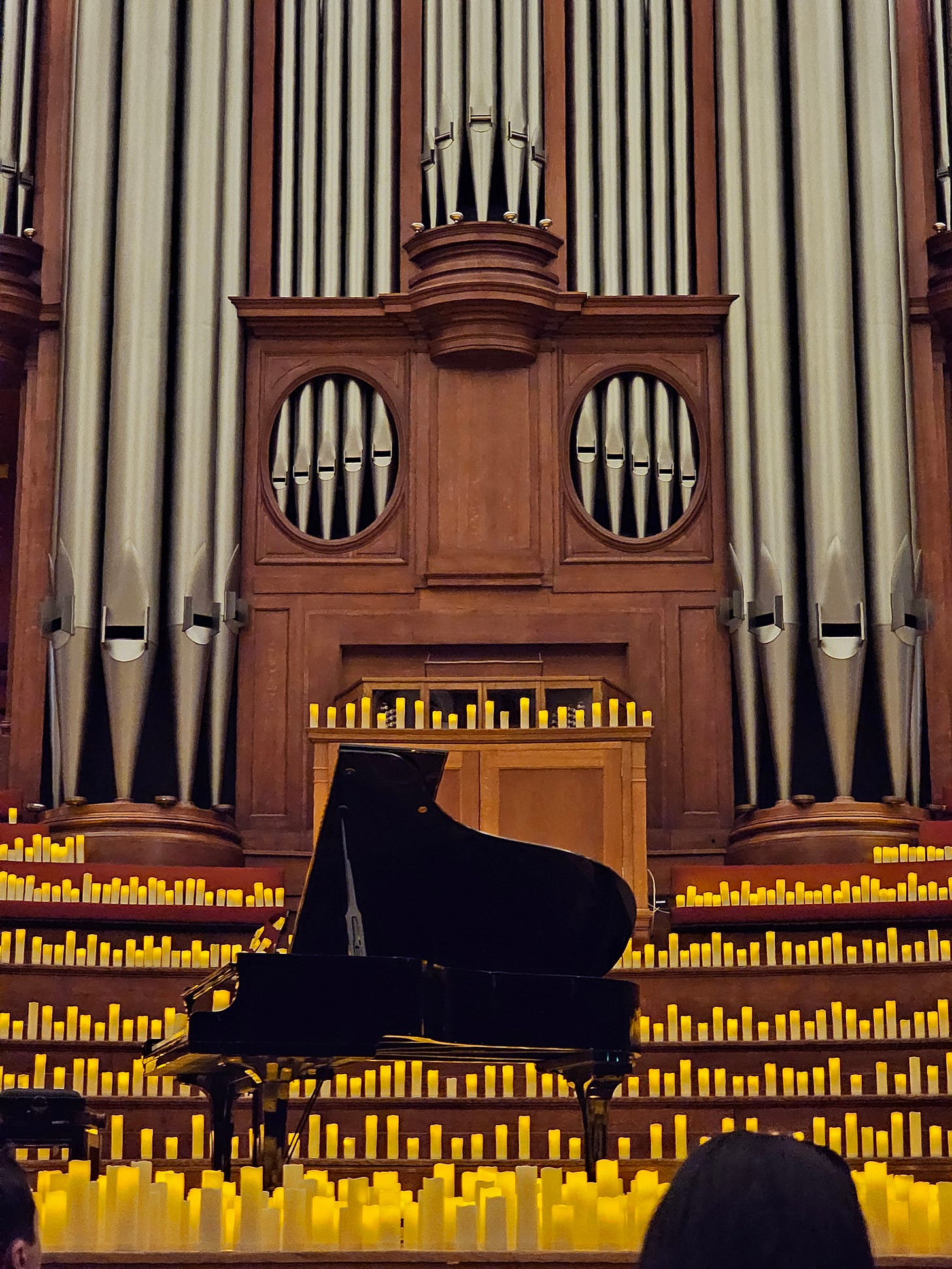grand piano in front of a large pipe organ in a church