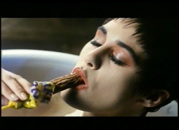 A still from a TV advert showing a woman in a bath biting into a Cadbury Flake