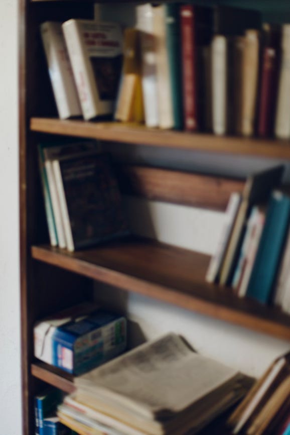 picture of a bookcase, partially empty, that is blurry and taken on film