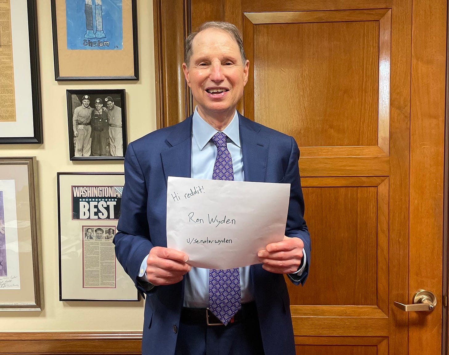 Color photo of Senator Ron Wyden, a white man with grey hair wearing a navy blue suit and purple tie.