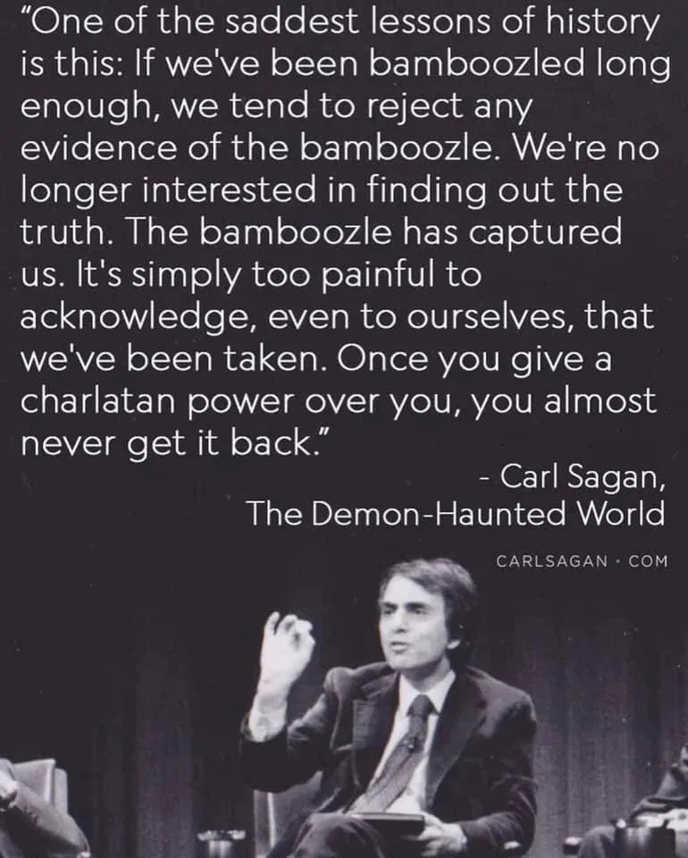 Image is a photo of Carl Sagan with his quote: "One of the saddest lessons of history is this: If we’ve been bamboozled long enough, we tend to reject any evidence of the bamboozle. We’re no longer interested in finding out the truth. The bamboozle has captured us. It’s simply too painful to acknowledge, even to ourselves, that we’ve been taken. Once you give a charlatan power over you, you almost never get it back." - Carl Sagan, the demon-haunted world, 1995