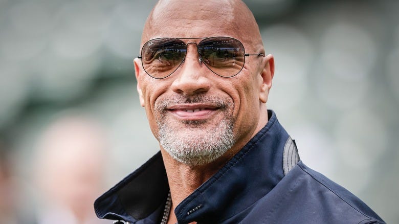Dwayne The Roc" Johnson smiling while wearing sunglasses