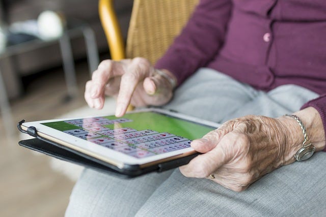 elderly woman playing on ipad