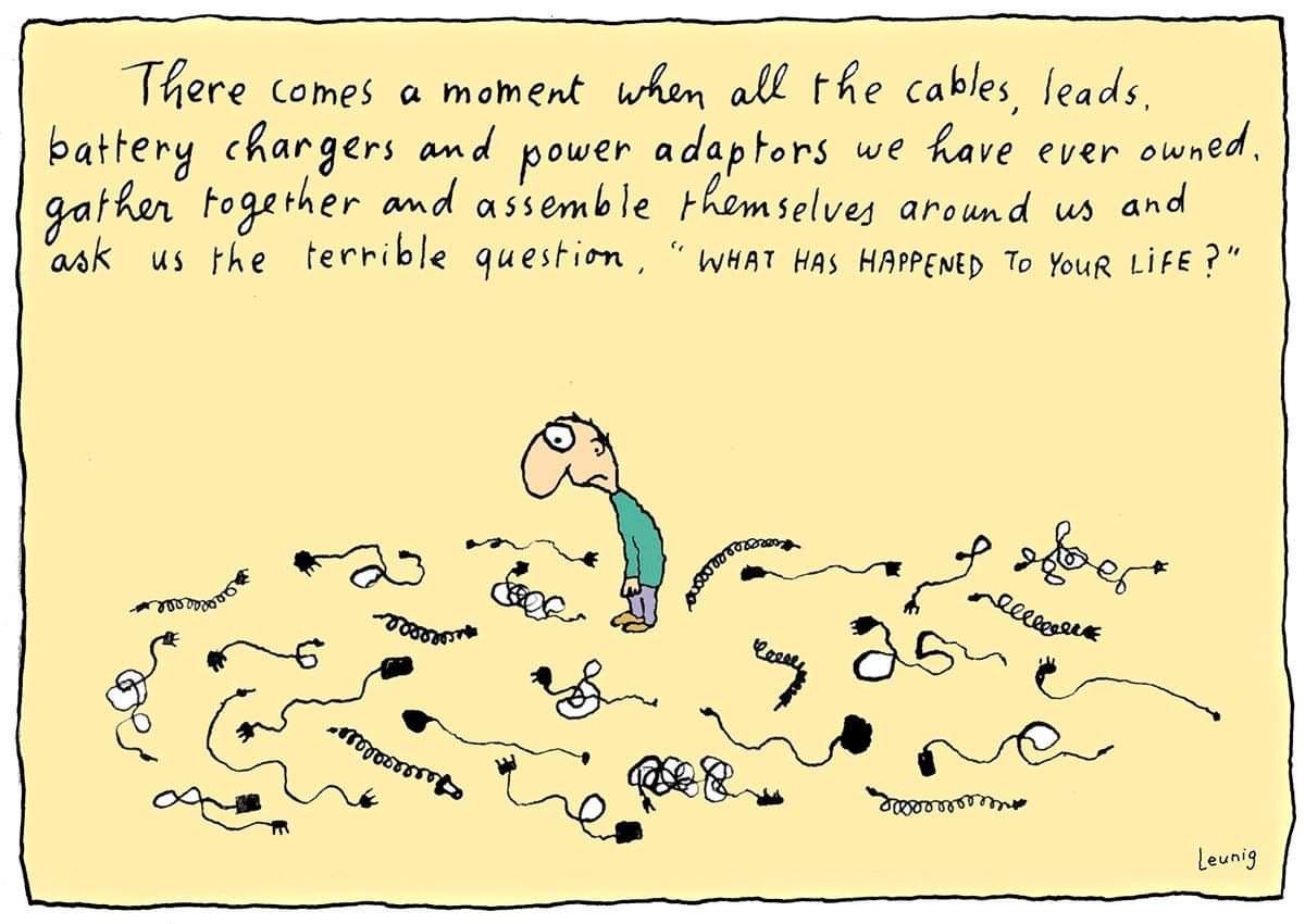 Cartoon: sad man surrounded by cables. Text: There comes a moment when all the cables, leads, battery chargers and power adaptors we have ever owned gather together and assemble themselves around us and ask the terrible question, "WHAT HAS HAPPENED TO YOUR LIFE?"