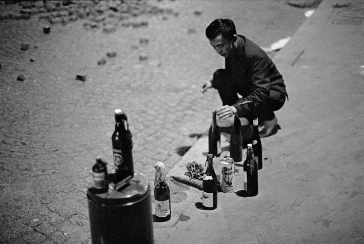 A protestor prepares Molotov cocktails during the May 1968 civil unrest in Paris.