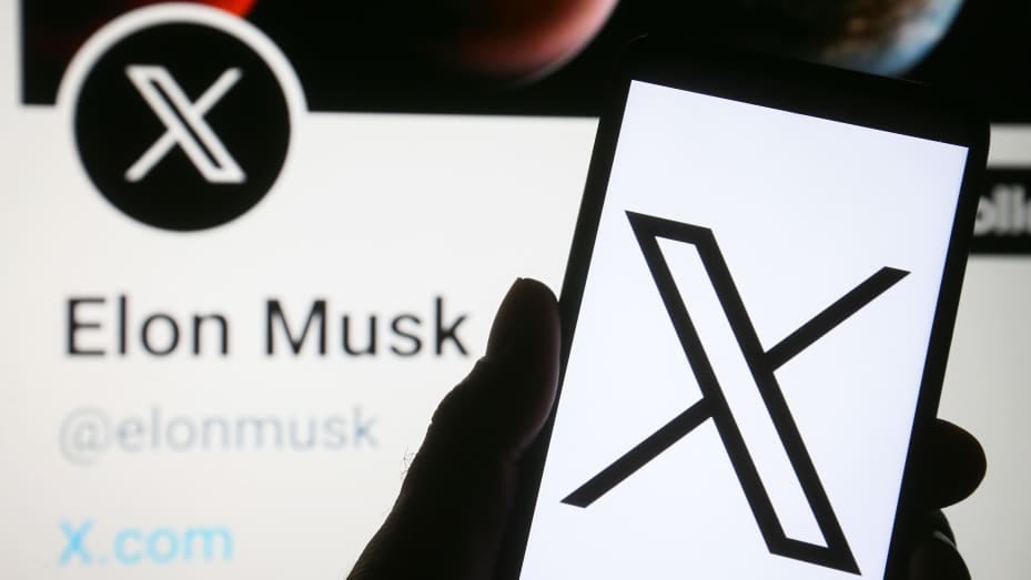 In this photo illustration, the new Twitter logo rebranded as X (X Corp.) is seen on a smartphone and Elon Musk Twitter account with the new X logo on a pc screen.