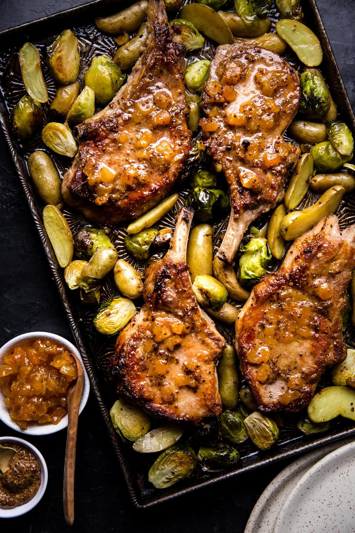 pork chops on a sheet pan with apricot dijon sauce, potatoes and Brussels