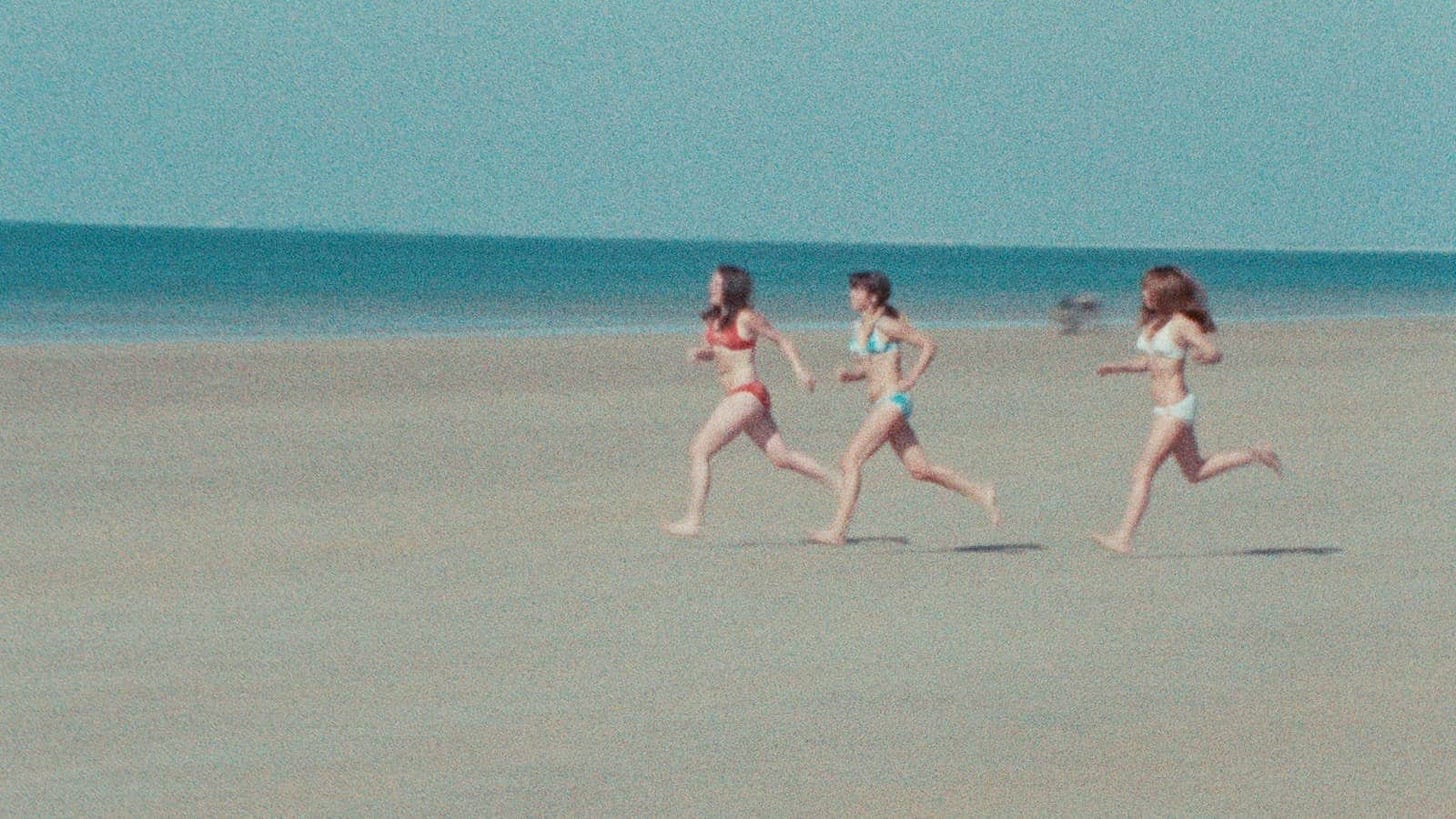 Near Orouët | Still features three girls running on a beach.