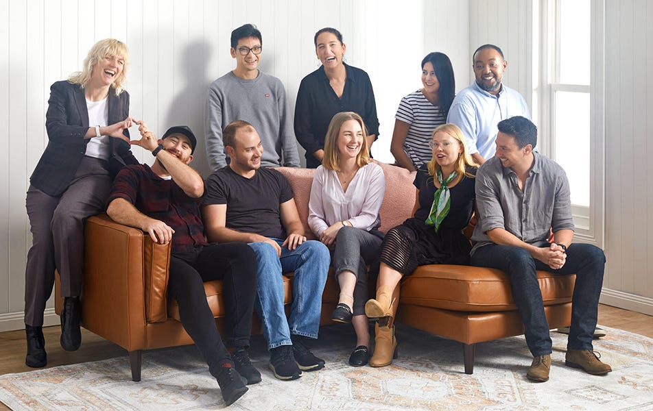 A diverse group of individuals sitting on couches engaged in conversation and laughter.