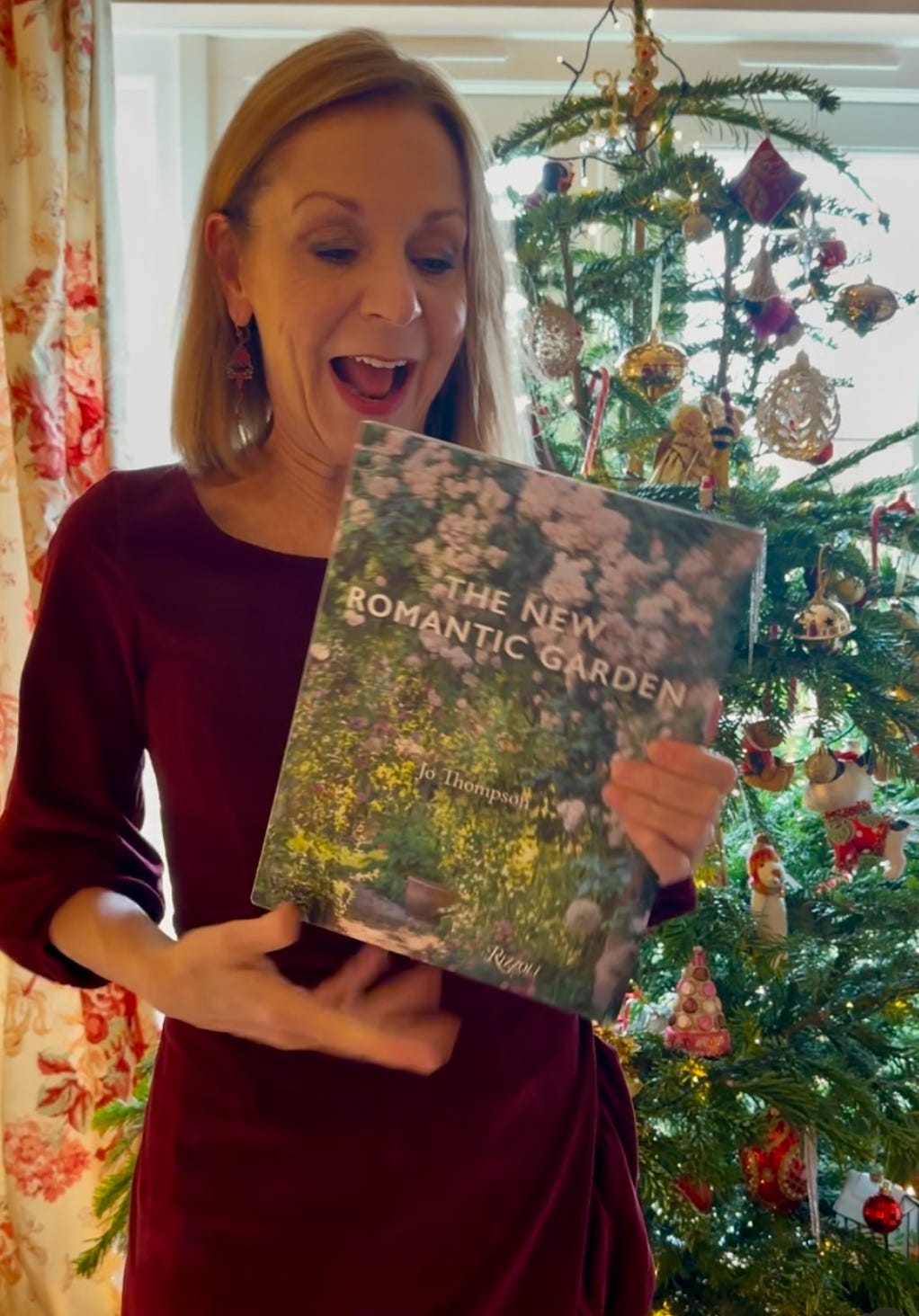 a woman holding a copy of the New Romantic garden