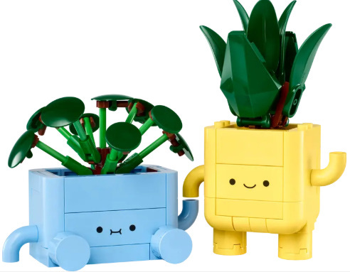 Two lego botanical plants, one sitting coloured blue and one standing, coloured yellow, nearly holding hands.
