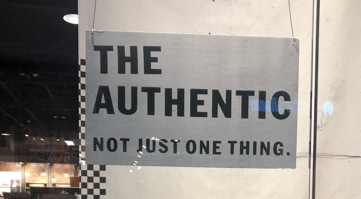 a sign in a store window that says "the Authentic not just one thing"