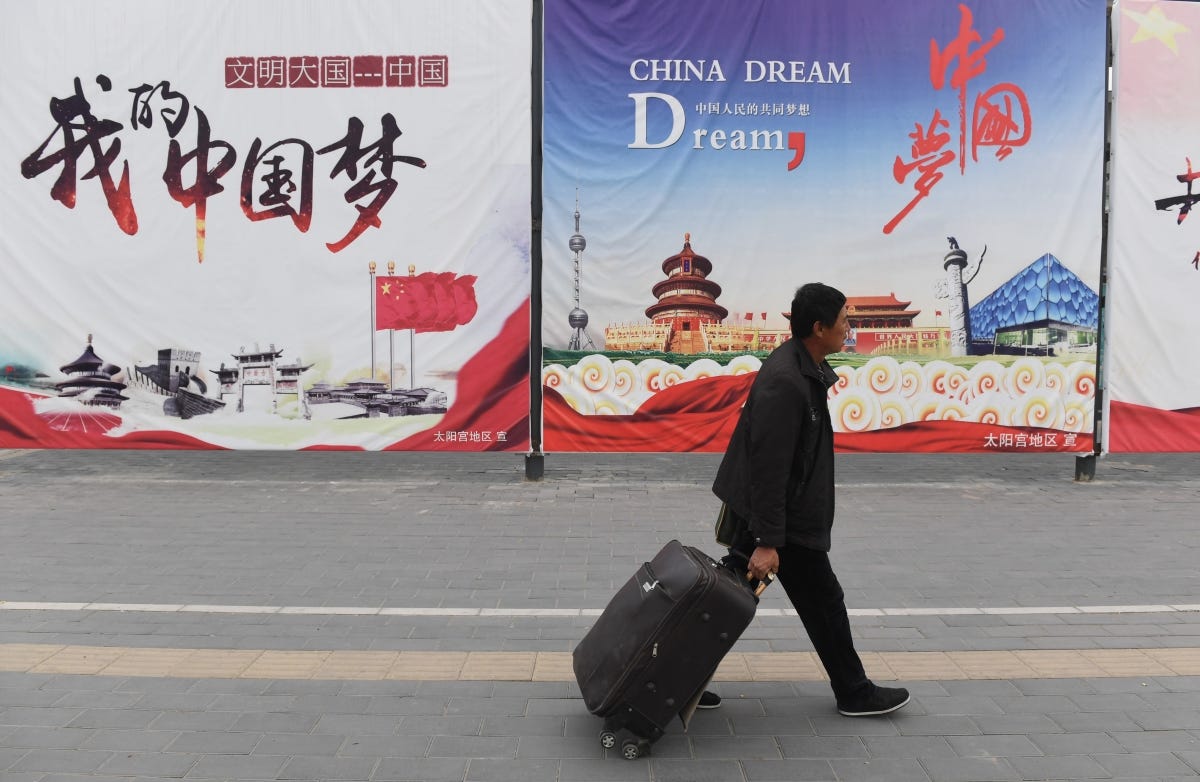 A man walks past billboards promoting the "China Dream"