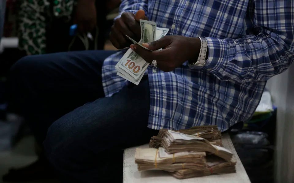 FILE- A trader counts US Dollars inside a shop in Lagos, Nigeria. Monday, June. 20, 2016. Nigeria's central bank has unified all foreign exchange rates, removing a significant distortion in the financial market in the latest move by policymakers in Africa's biggest economy to woo investors and help stabilize the local currency, Angela Sere-Ejembi, director of financial markets at the Central Bank of Nigeria, said on Wednesday, June 14, 2023. (AP Photo/Sunday Alamba, File)