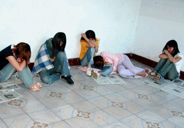 Group of young Chinese prostitutes huddle in a room after police raided a brothel in Xuchang, central China's Henan province, 20 May 2005. Following...