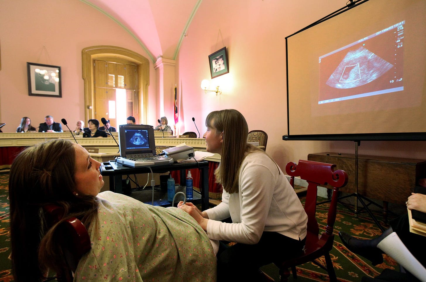 A pregnant Erin Glockner, left, is given an ultrasound by Julie Aber of Ashland Care Center during a committee hearing at the Ohio Statehouse in 2011. Anti-abortion advocates presented live ultrasounds to lawmakers in support of a bill that would outlaw abortion when cardiac activity can be detected.