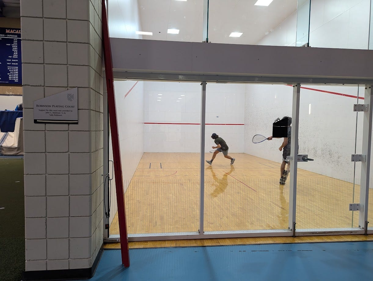 A racquetball court in use by two seemingly intense players