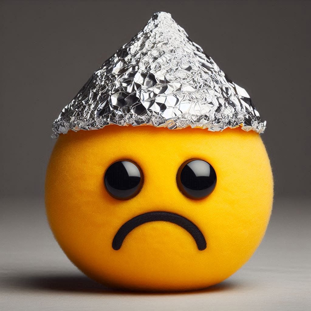 a smiley face with a frown wearing a tinfoil hat