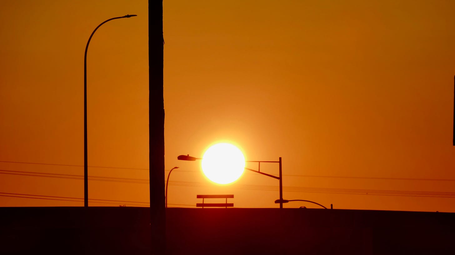 Sunrise over freeway and streetlamps