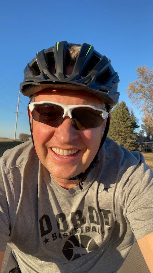 A selfie of Dr. Dave with his bike helmet and riding glasses in place with a huge grin about the bike ride he is on.