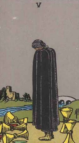 Five of Cups Card from Rider Waite Tarot deck. A cloaked figure stands between three spilled cups to the fore, and two upright sit behind him.