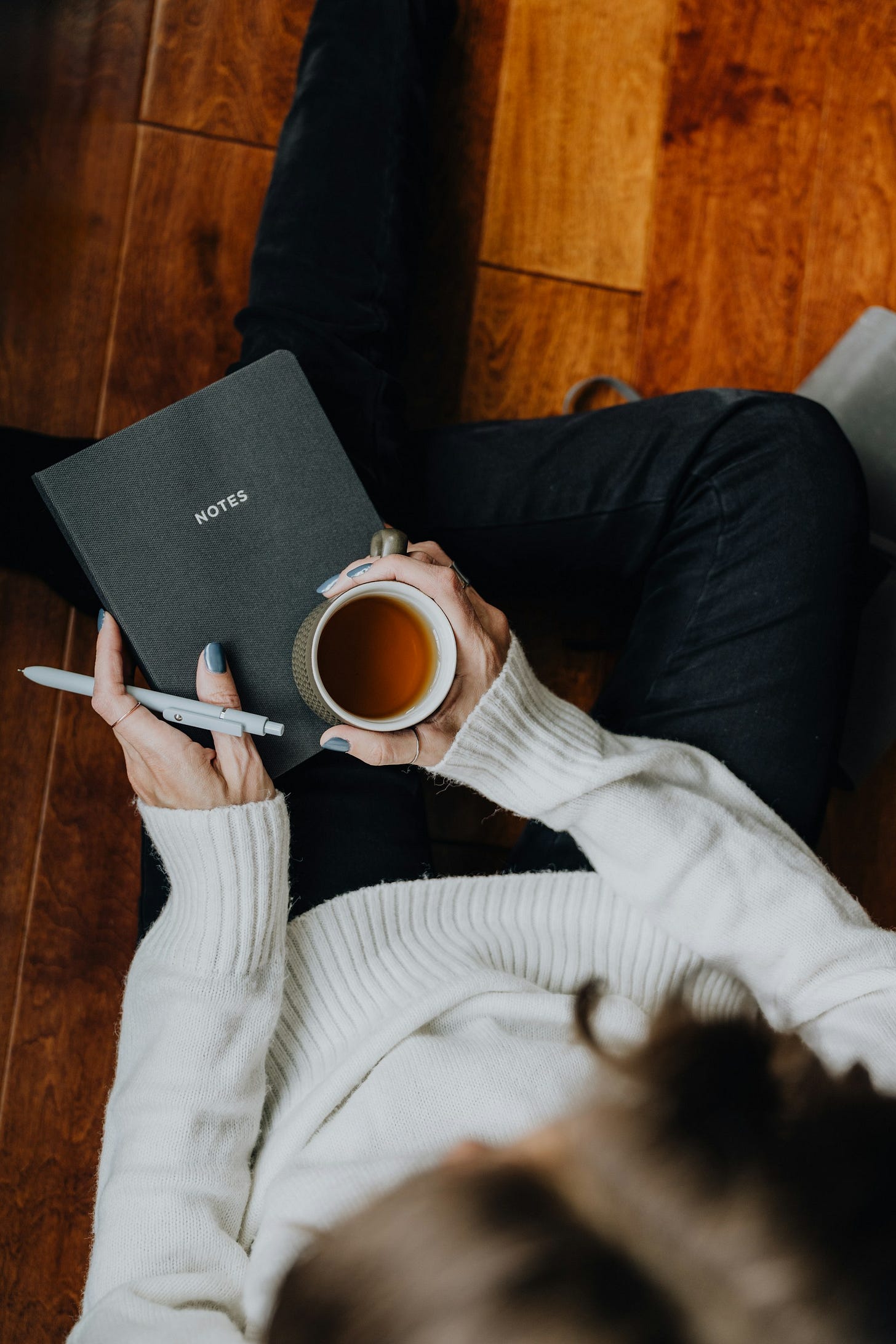 A woman holding a cup of coffee and a book