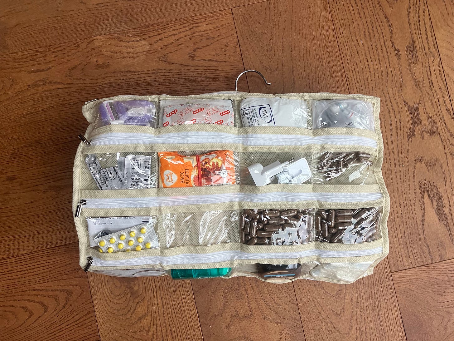 Plastic hanging pocket organizer folded up and laid against wood floor.