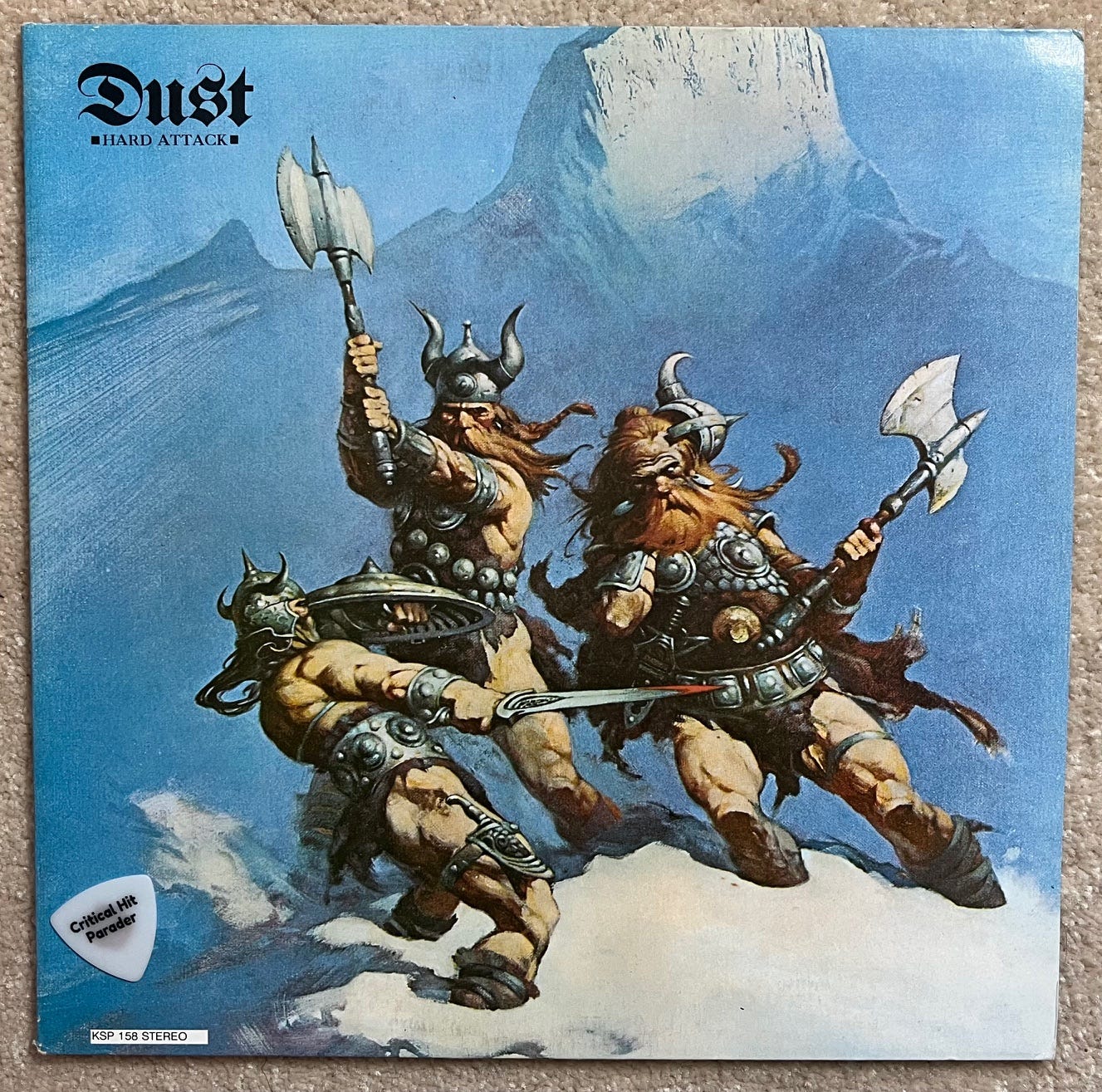 Album cover for Hard Attack by Dust, featuring a Frank Frazetta painting of three barbarian-like figures fighting in the mountain snow.