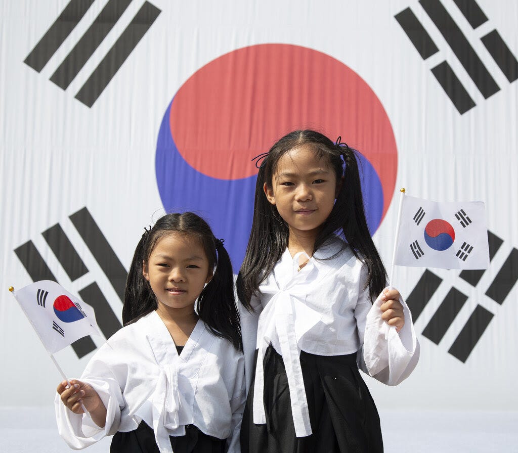 Two girls holding South Korean flags.