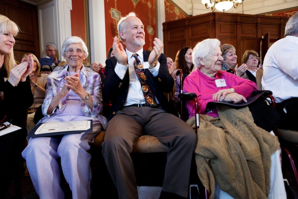 Group of people clapping in an audience setting