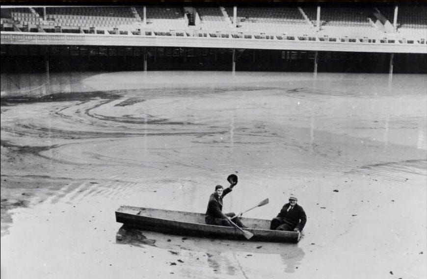 Gene Schott and Lee Grissom in a boat above home plate inside flooded Crosley Field.