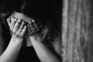 indian woman crying into hands in grief bw picture