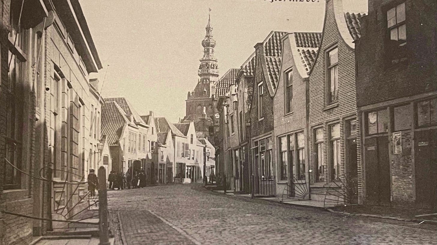 all five photos are described in the text. this first one from 1903 is of course in black and white. It shows a street in 1903 with hardly any people in the photo, in the distance is an ornamented tower from the (then) town hall that now houses the city museum