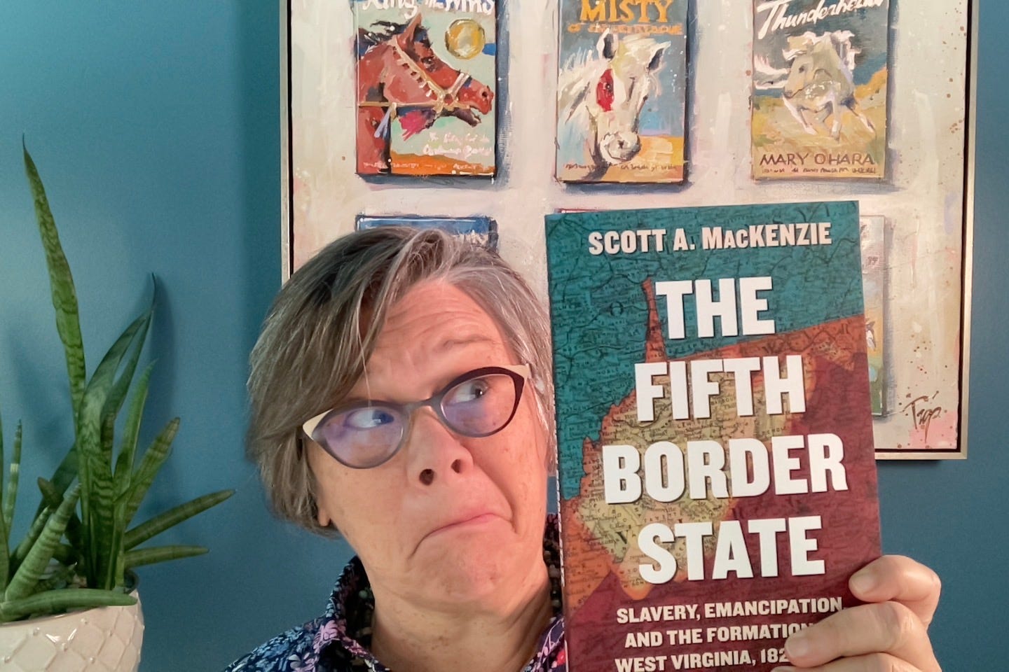 Tamela holding her copy of "The Fifth Border State" book by Scott A. Mackenzie
