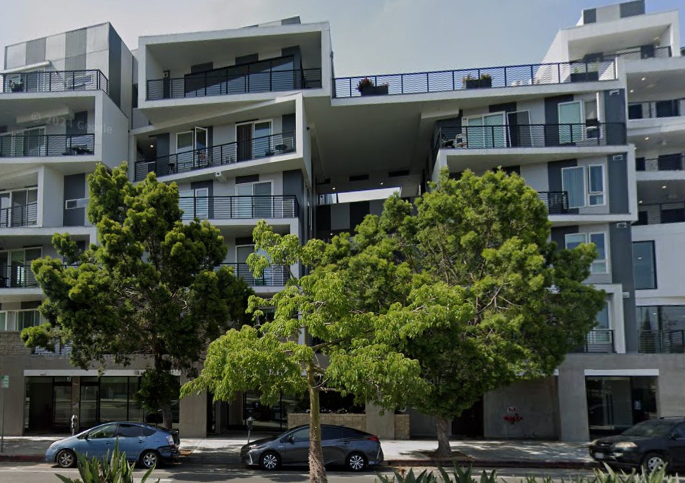 Modern gray and white six story building that appears to have no tenants.