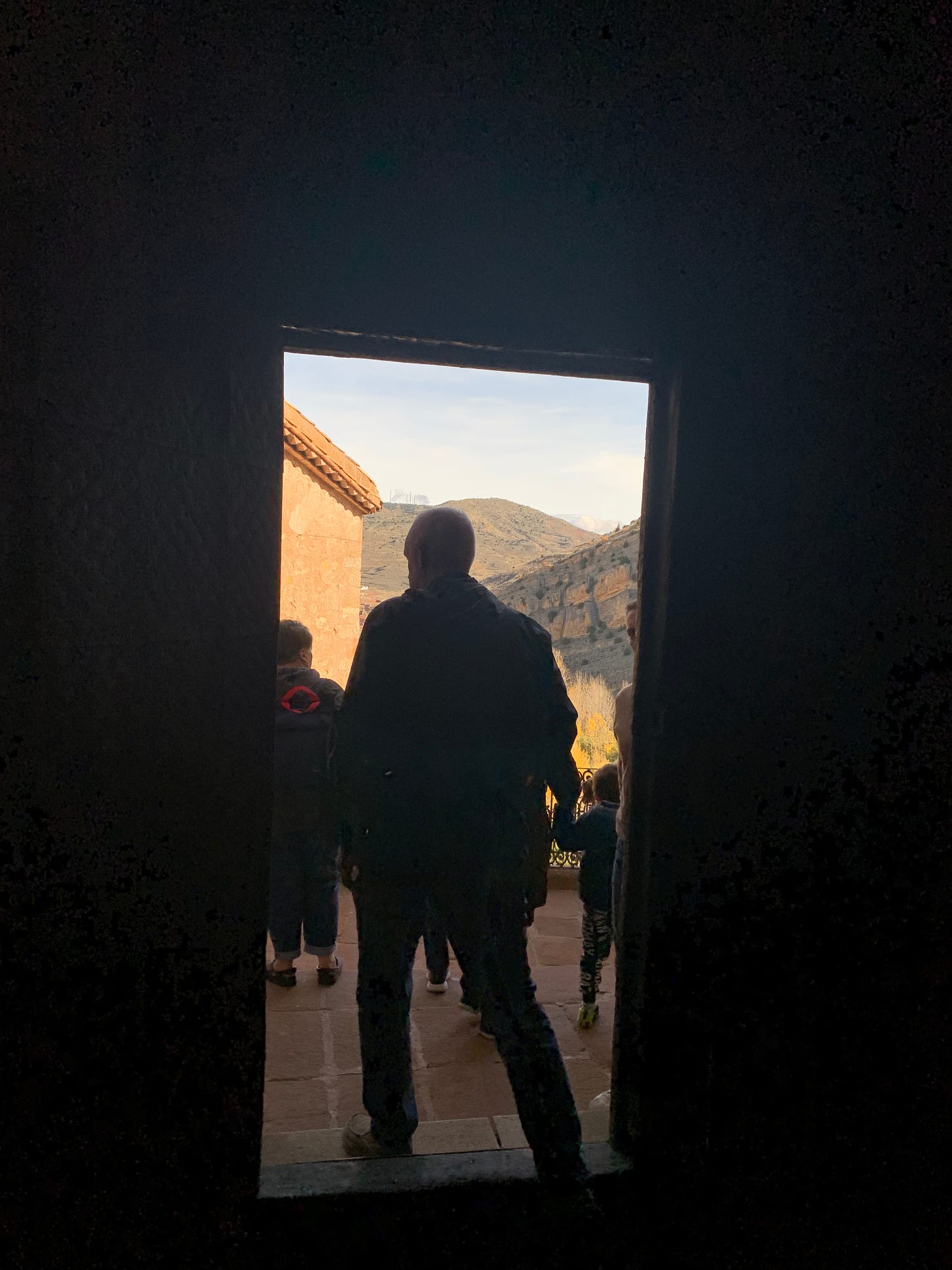 Dark metal doorway shows Jim leaving the cloister.